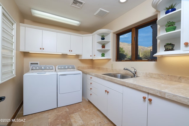 laundry room featuring sink, cabinets, and independent washer and dryer