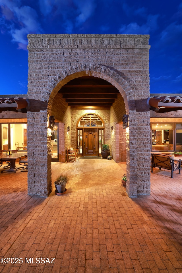 exterior entry at dusk with a patio area