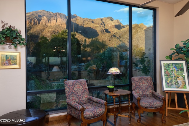 sitting room with a mountain view and hardwood / wood-style flooring