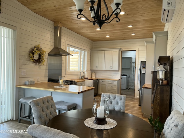 16911 S Joshua Tree Rd, Mayer, AZ 86333 - dining space featuring wood ceiling, light wood-type flooring, a chandelier, a wall unit AC, and wood walls