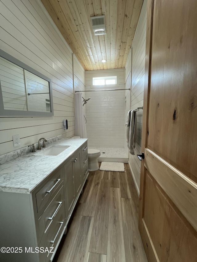 16911 S Joshua Tree Rd, Mayer, AZ 86333 - bathroom with toilet, a shower stall, wood finished floors, vanity, and wooden walls
