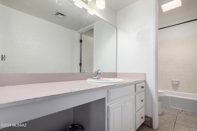 full bathroom featuring vanity, tiled shower / bath, a skylight, tile patterned flooring, and toilet