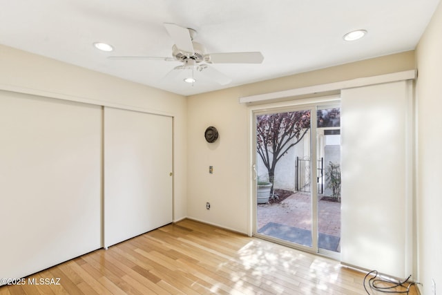 unfurnished bedroom featuring access to exterior, light hardwood / wood-style floors, a closet, and ceiling fan