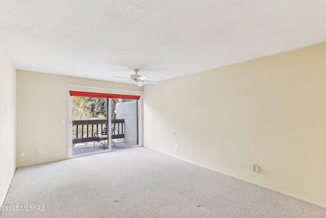 empty room featuring ceiling fan, carpet, and a textured ceiling