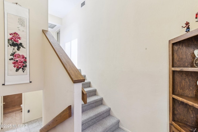 stairs featuring tile patterned flooring