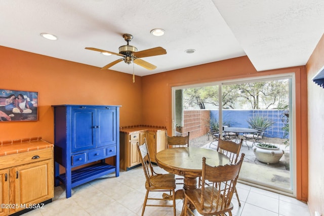 dining room featuring light tile patterned floors, a textured ceiling, and ceiling fan