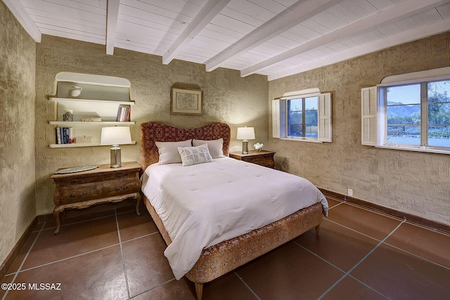 bedroom with dark tile patterned floors and beam ceiling