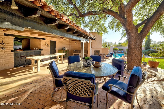 view of patio with a fenced in pool, an outdoor fireplace, exterior bar, and ceiling fan