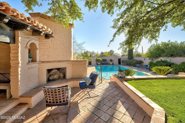 view of pool featuring an outdoor brick fireplace and a patio