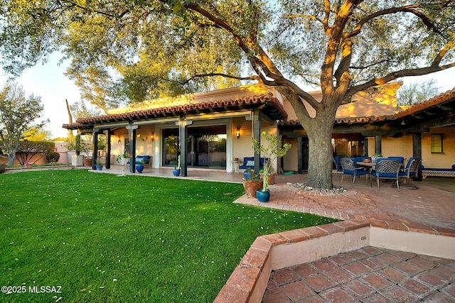 rear view of property with a patio and a yard