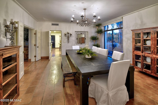 dining room featuring crown molding and a notable chandelier