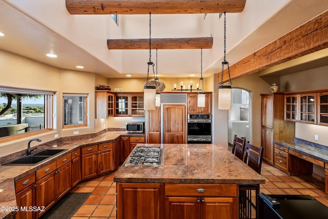 kitchen with a kitchen bar, stainless steel appliances, sink, pendant lighting, and a center island