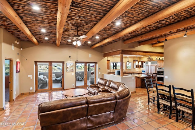 tiled living room featuring ceiling fan, a towering ceiling, beamed ceiling, and wood ceiling