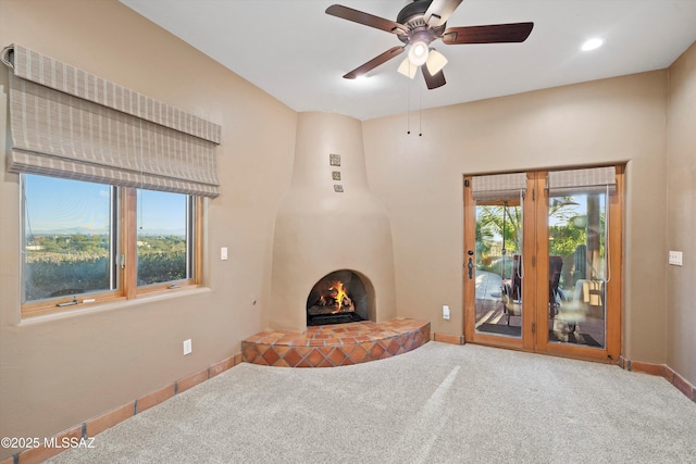 unfurnished living room with carpet flooring and ceiling fan