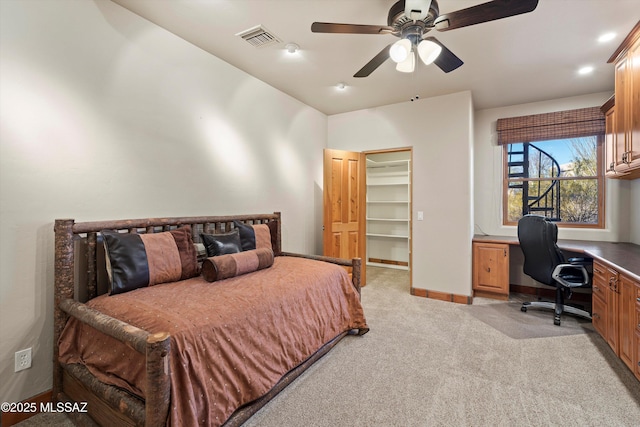 carpeted bedroom with a spacious closet, ceiling fan, vaulted ceiling, a closet, and built in desk