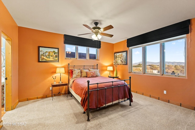 bedroom featuring carpet flooring, a mountain view, and ceiling fan