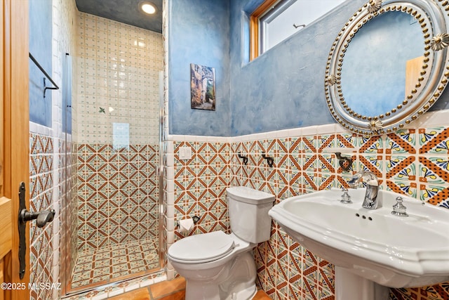 bathroom with sink, tile patterned flooring, tile walls, and toilet