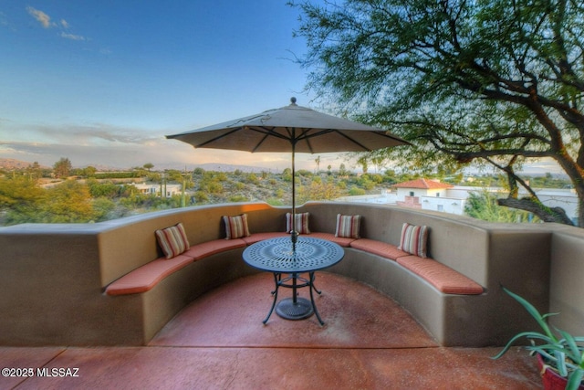 patio terrace at dusk featuring a balcony