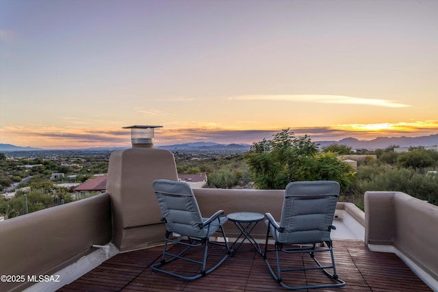 deck at dusk featuring a mountain view