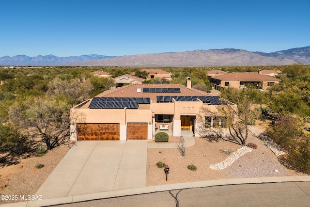 view of front of property featuring a mountain view and solar panels