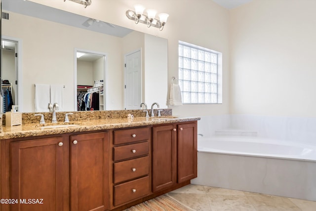 bathroom featuring a tub, tile patterned flooring, and vanity