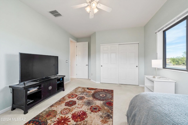 carpeted bedroom featuring a closet and ceiling fan