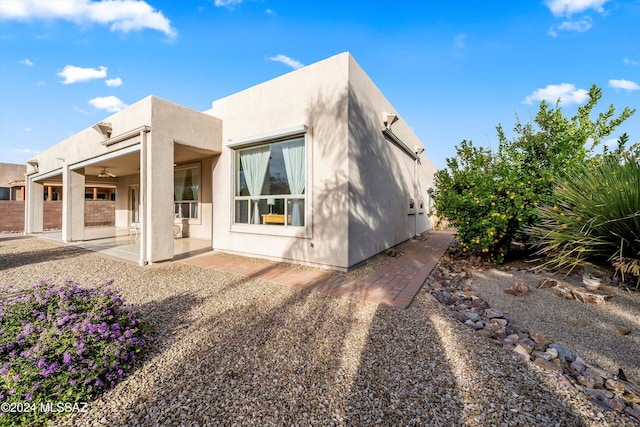 rear view of property with ceiling fan and a patio