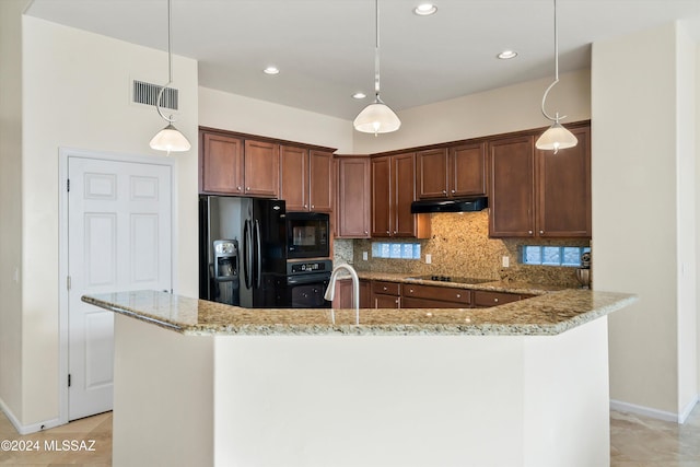 kitchen featuring backsplash, light stone countertops, pendant lighting, and black appliances