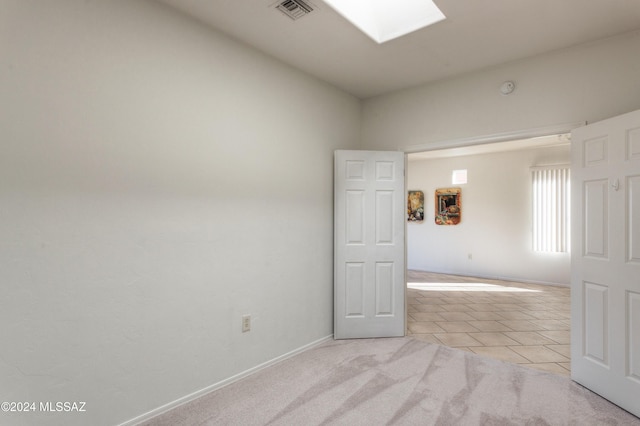 carpeted empty room with a skylight