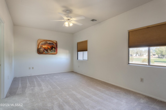 unfurnished room featuring light colored carpet and ceiling fan