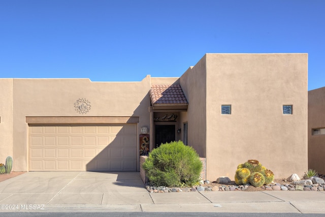 pueblo revival-style home with a garage