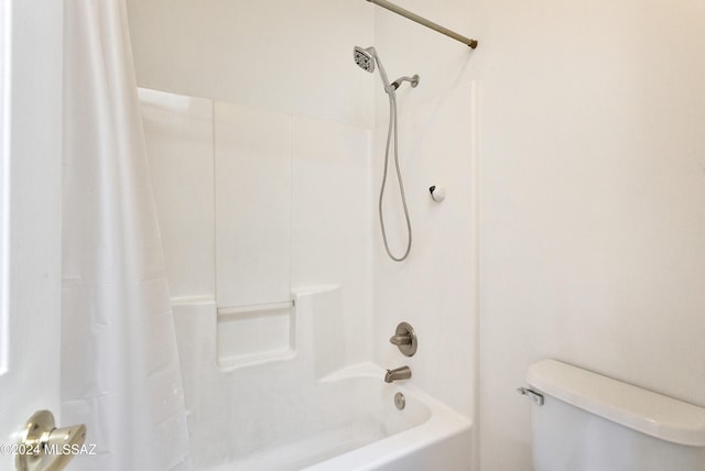 bathroom with shower / bathtub combination with curtain and toilet