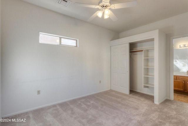 unfurnished bedroom with ceiling fan, light carpet, and a closet