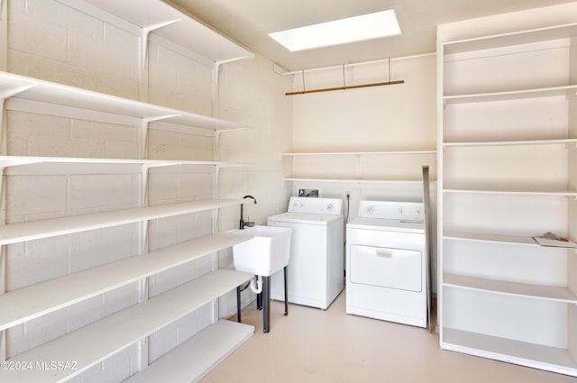 washroom featuring a skylight and washing machine and clothes dryer