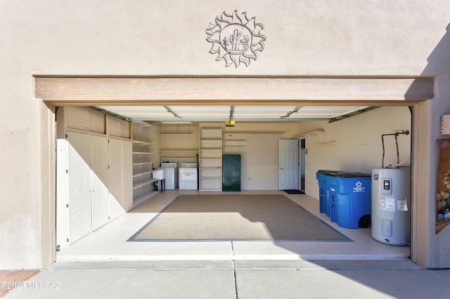 garage with washing machine and clothes dryer, electric water heater, and sink