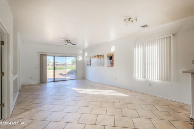 empty room with ceiling fan and light tile patterned floors