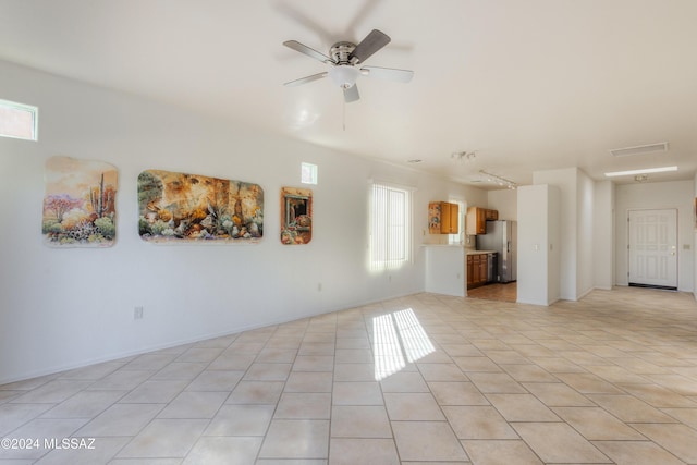 unfurnished living room featuring ceiling fan, light tile patterned floors, and a healthy amount of sunlight