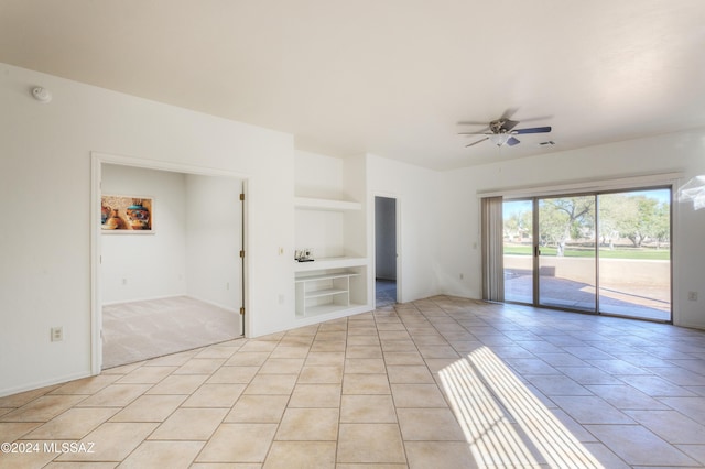 unfurnished room with ceiling fan, built in features, and light tile patterned floors