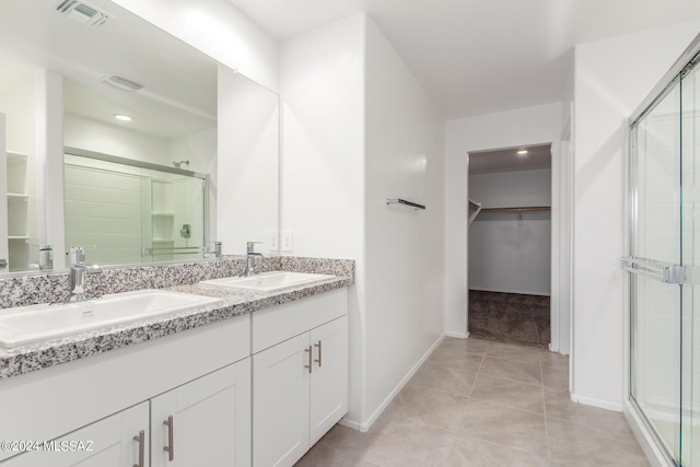 bathroom with tile patterned flooring, vanity, and an enclosed shower