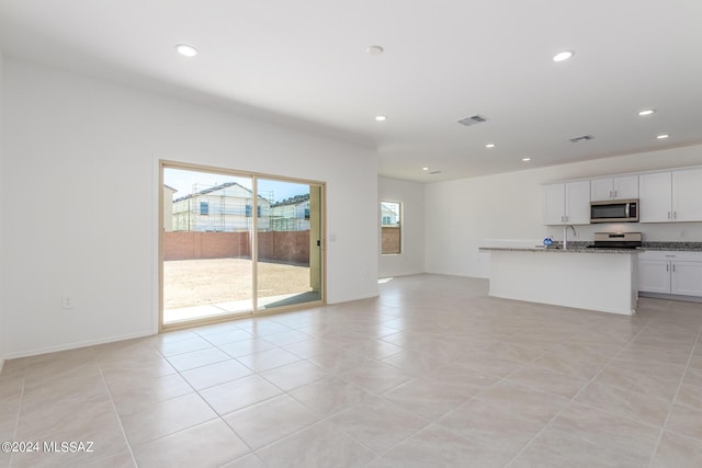 unfurnished living room featuring sink and light tile patterned flooring