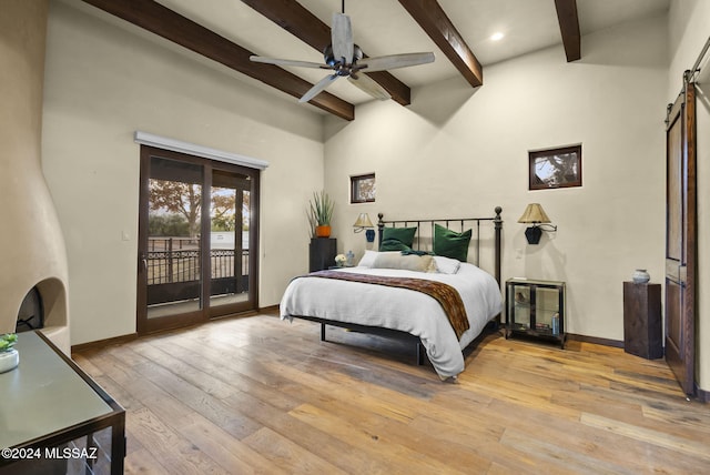 bedroom featuring ceiling fan, access to exterior, a towering ceiling, beamed ceiling, and light hardwood / wood-style floors