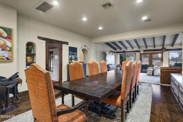 dining room featuring vaulted ceiling with beams and dark wood-type flooring