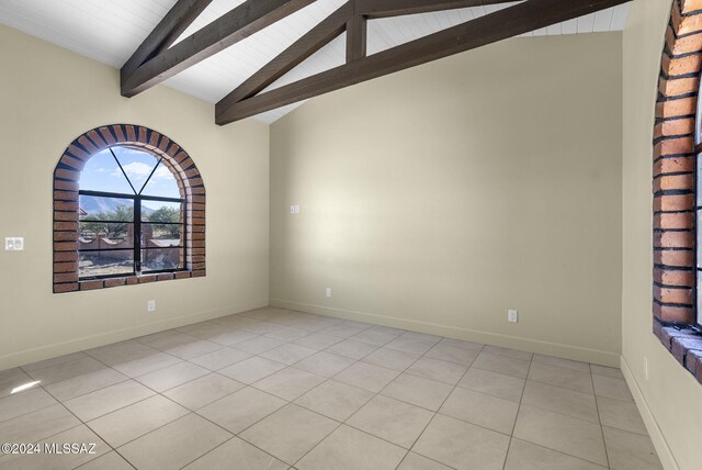 spare room with light tile patterned floors, lofted ceiling with beams, and wood ceiling