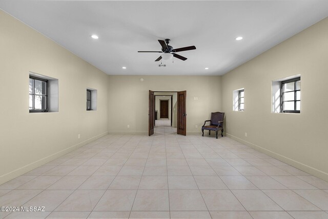 tiled spare room with ceiling fan