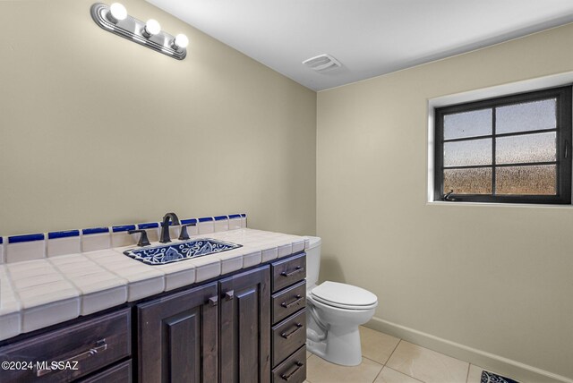 bathroom with tile patterned flooring, vanity, and toilet