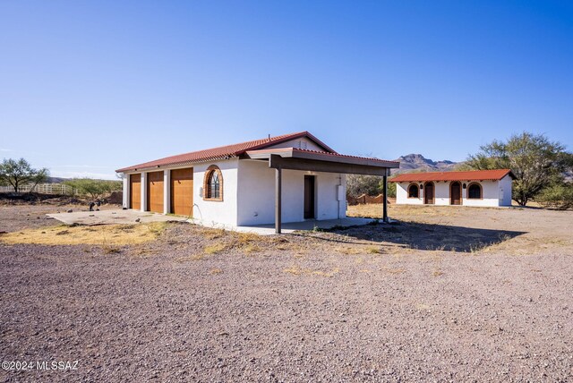 view of front of house featuring a carport and an outdoor structure