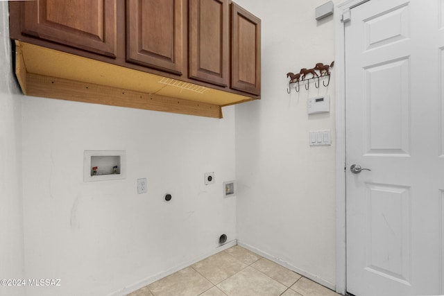 clothes washing area with washer hookup, electric dryer hookup, cabinets, and light tile patterned floors