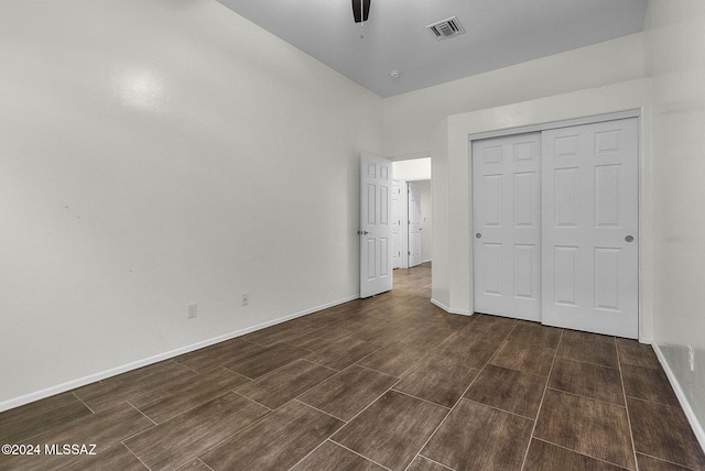 unfurnished bedroom with ceiling fan and a closet