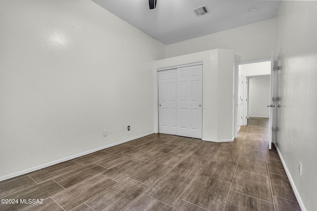 unfurnished bedroom with dark hardwood / wood-style floors, ceiling fan, and a closet