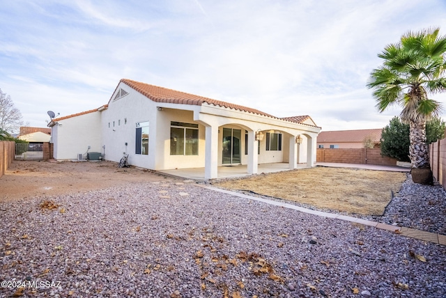 back of house with central AC unit and a patio